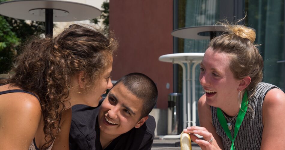Drei Menschen sitzen und lachen zusammen.